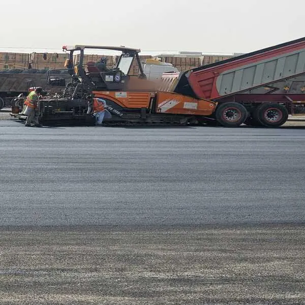 مقاول اسفلت بيش 1 فرد الأسفلت بماكينة الفرش مع شاحنة قلاب أثناء سفلتة ساحة واسعة